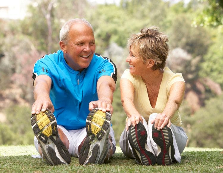 older man and woman stretching before a run