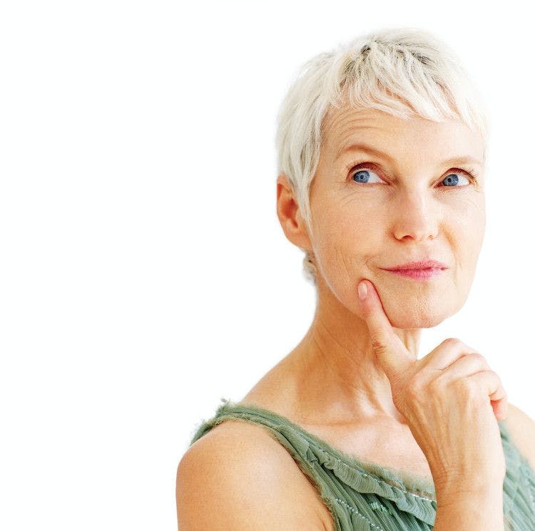 older woman with a smirk in deep thought with finger on her chin