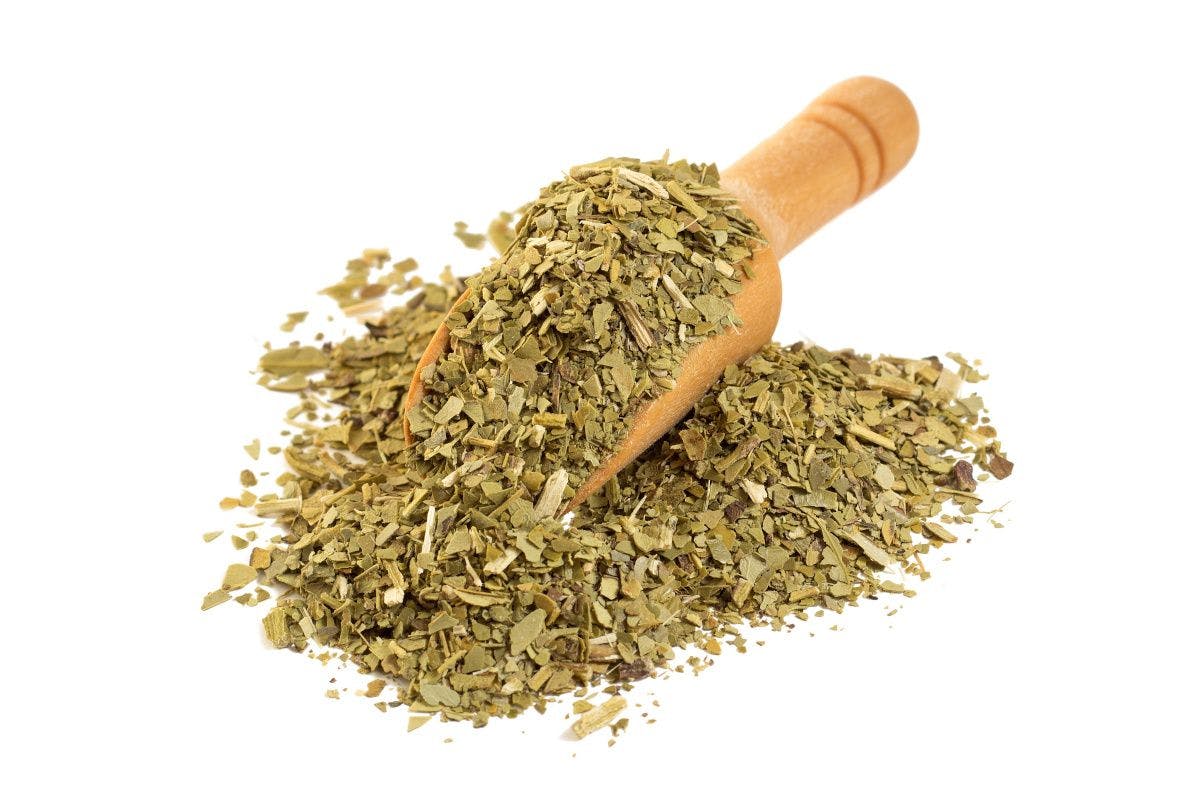 yerba maté in a wooden spoon on white background