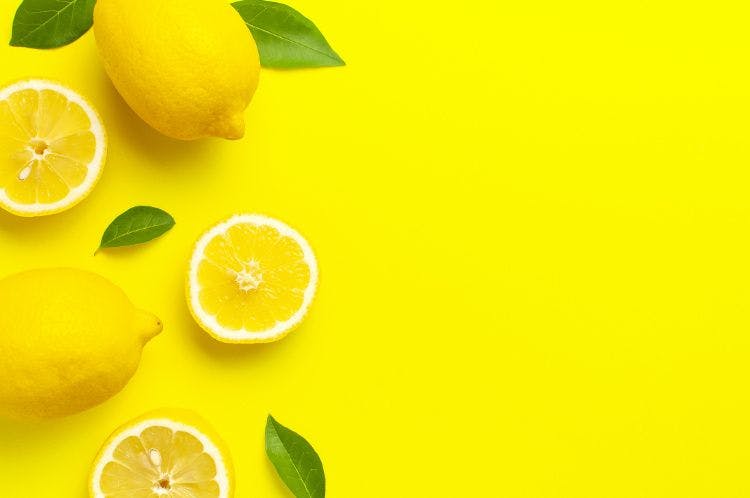 lemons and lemon slices on yellow background