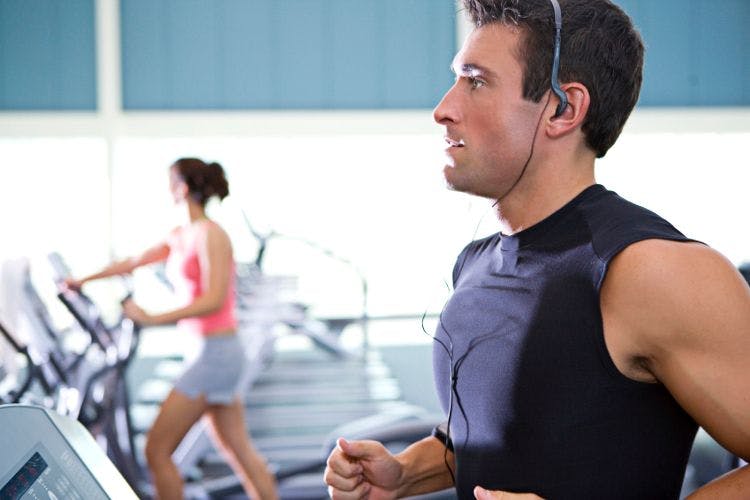 man with earphones, running on treadmill