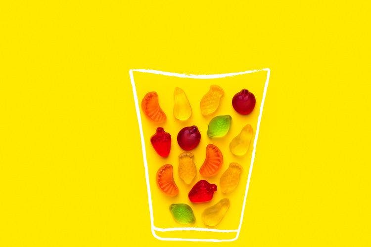 gummies on yellow background place inside of a cup drawn in white ink