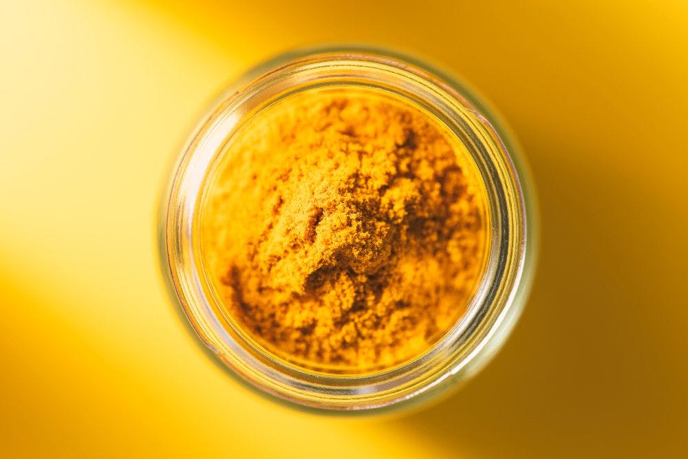 top view of turmeric powder in glass bottle