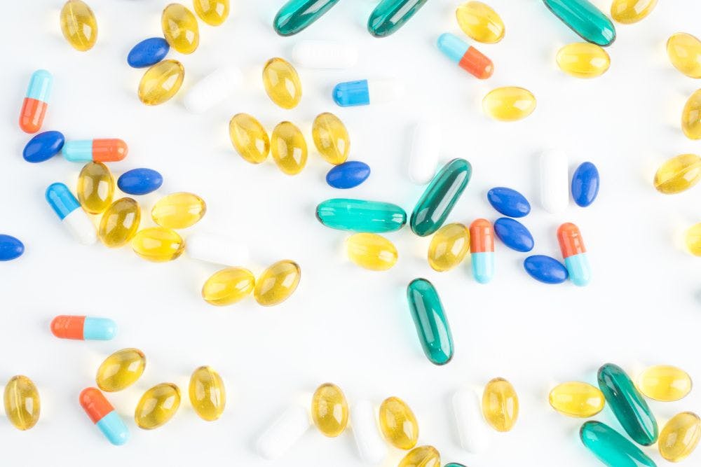 assortment of softgels and capsules on white backdrop