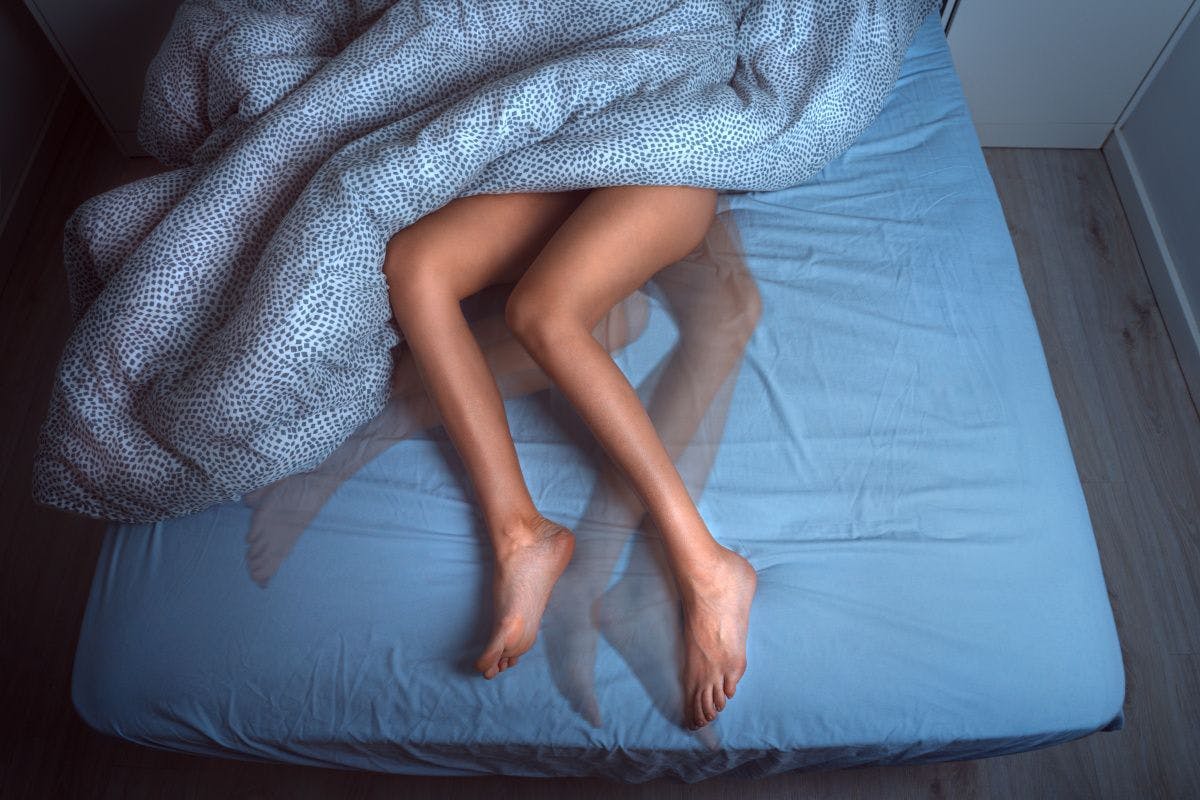 woman's legs tossing and turning in bed