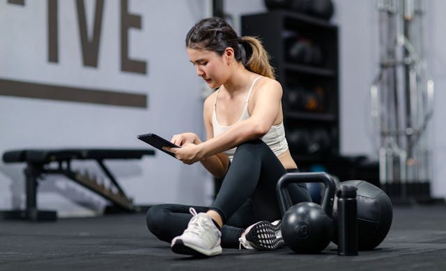 woman in the gym looking at her phone
