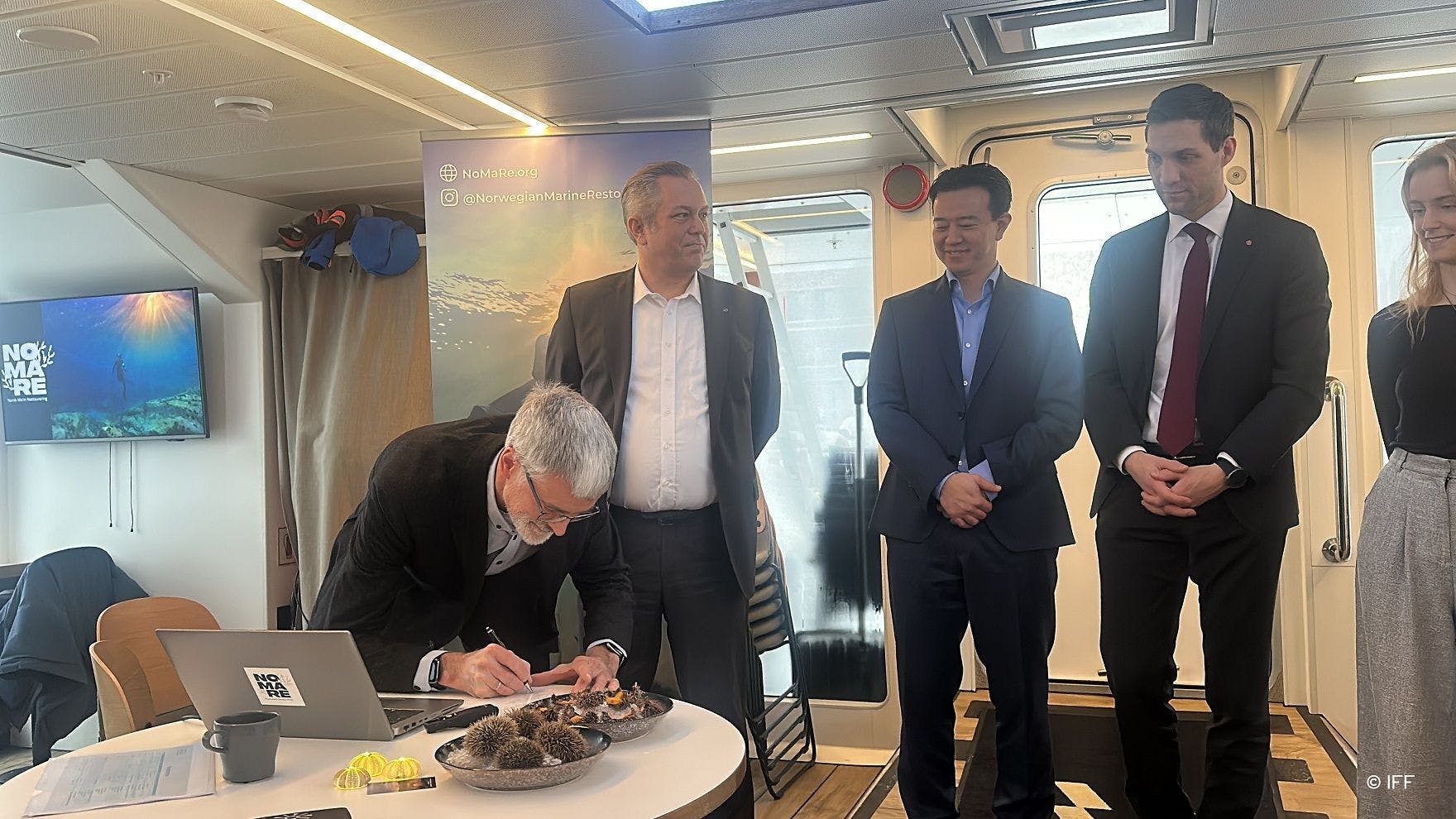 Trond Helgerud signs Norwegian Marine Restoration Project agreement along with Joakim Hauge from Bellona NGO; Brian Tsuyoshi Takeda, founder of Urchinomics; Andreas Bjelland Eriksen, Norway’s Minister of Climate and Environment, and Ida Søhol, co-leader of Tarevoktere. Image courtesy of IFF.