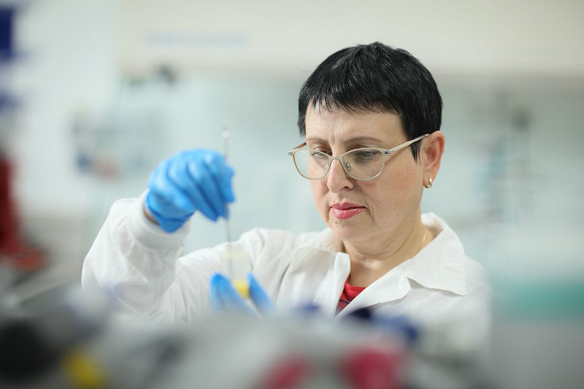 Evgenia Lozinsky, PhD, TopGum’s vice president of research and development in the lab holding a test tube
