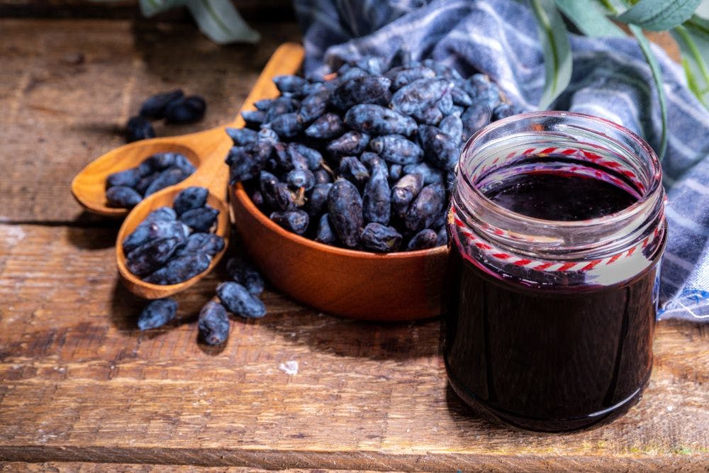 blue honeysuckle berries in bowl and jar of jam