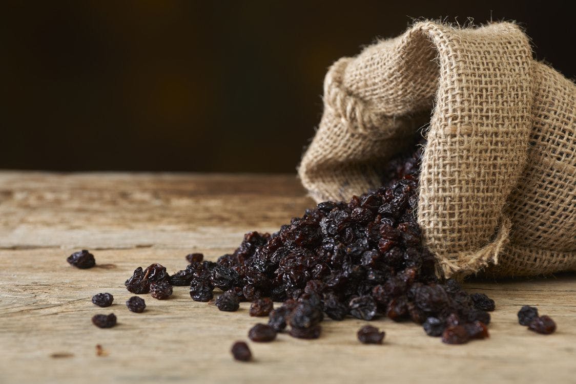 raisins pouring out of burlap sack