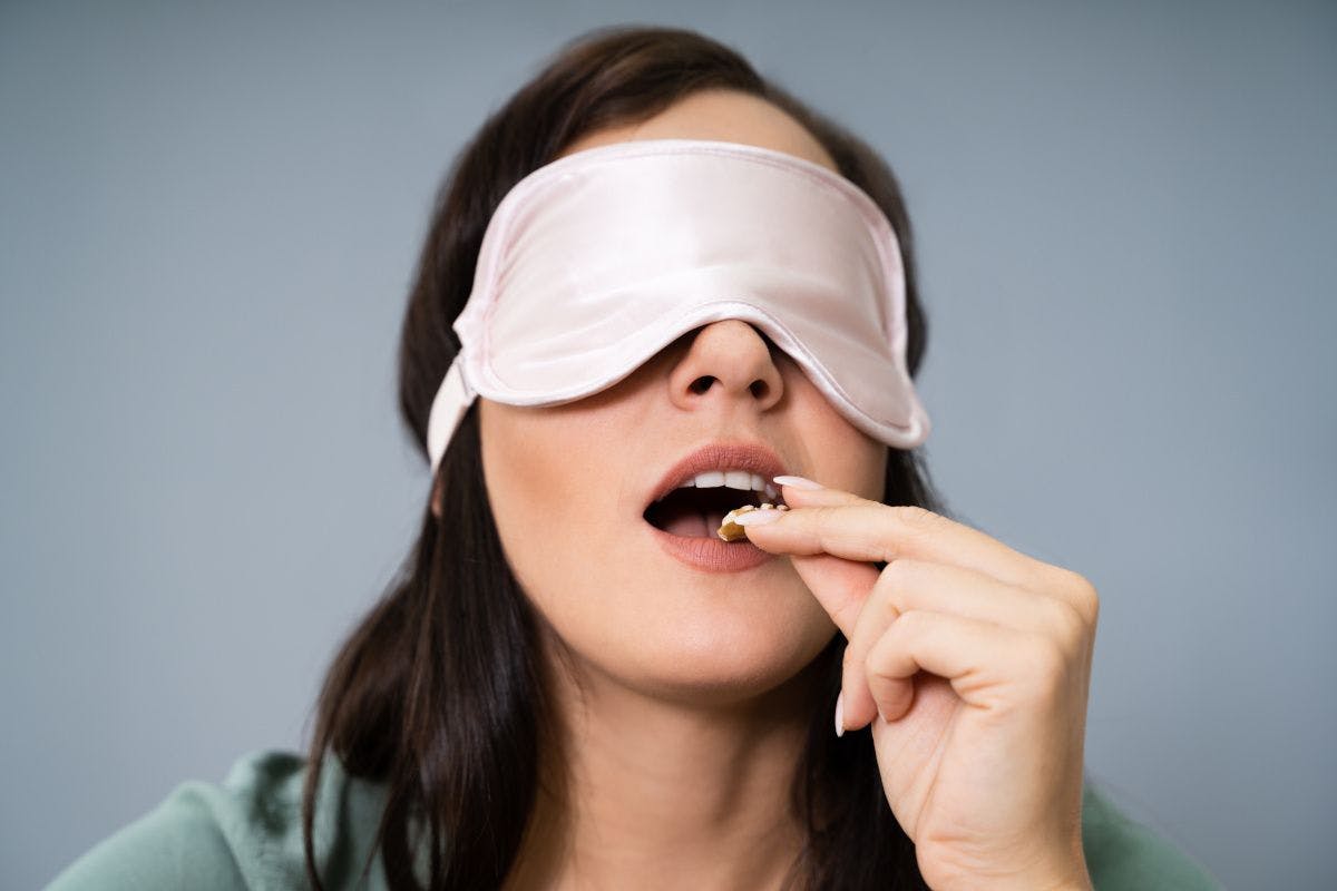 blindfolded woman tasting food